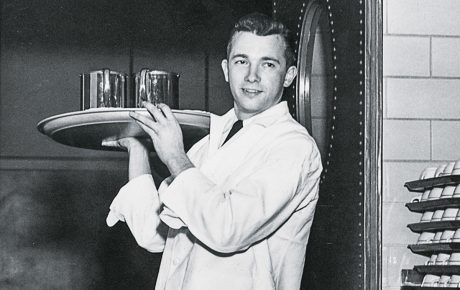 a waiter comes through a doorway with a tray on his shoulder at the Ratty